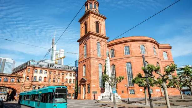 Paulskirche in Frankfurt von unten. Vor der Kirche fährt eine Straßenbahn.