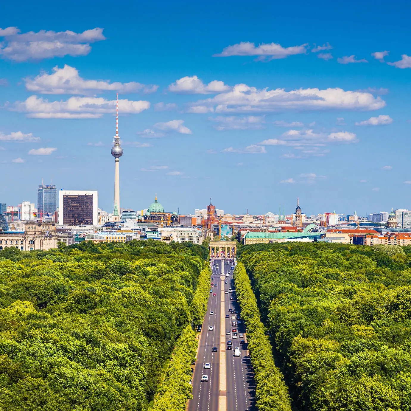 Blick über den Tiergarten auf die Skyline von Berlin. In der Mitte steht das Brandenburger Tor.