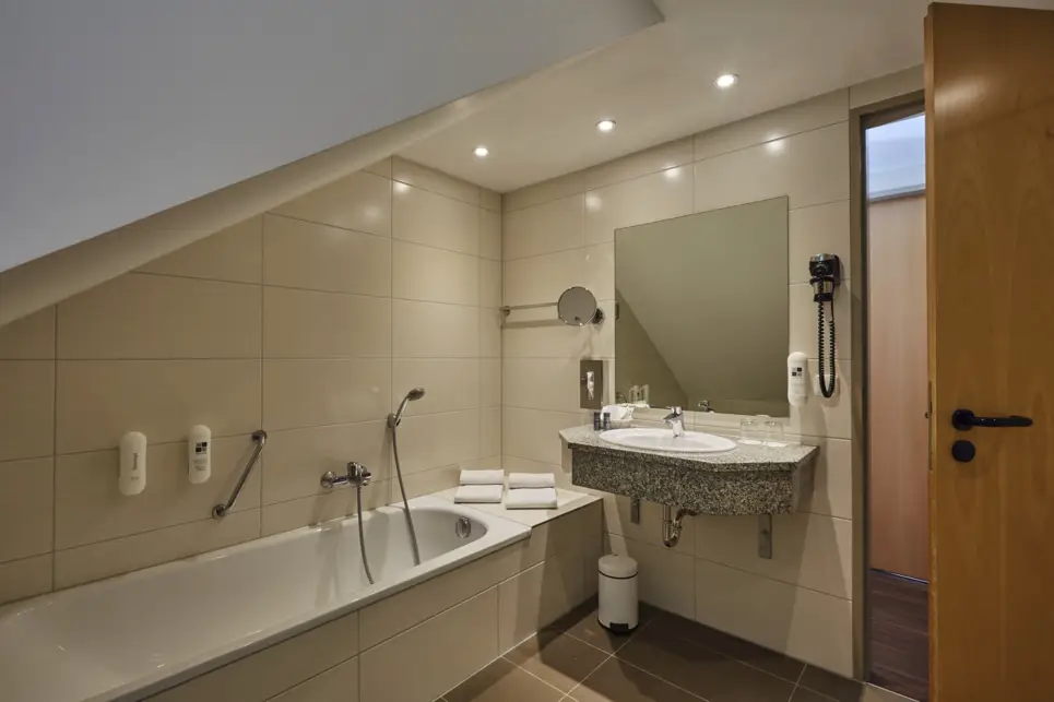 Salle de bains avec une grande baignoire et un lavabo à côté.