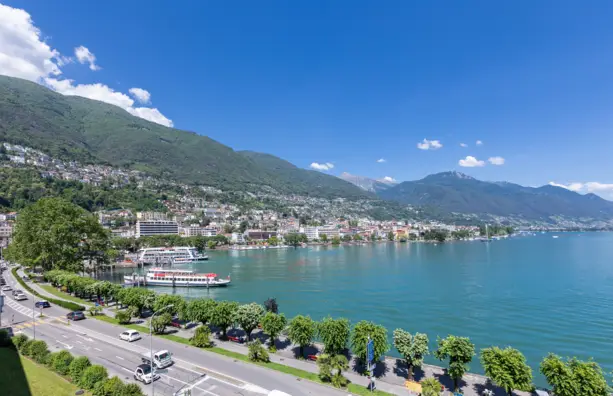 Promenade von oben entlang des Lago Maggiores. Im Hintergrund ist  Locarno und viele Berge.