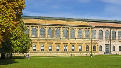 Außenfassade von der alten Pinakothek. Vor der Pinakothek steht ein großer Baum.