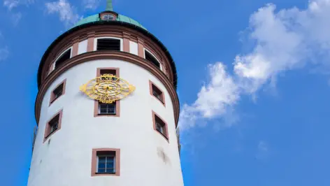 Oberer Teil des Weißen Turms mit einem goldenem Ziffernblatt.