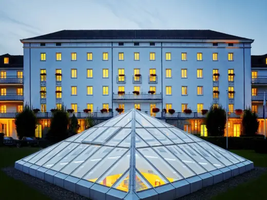 Blick durch die gläserne Pyramide vom Hotel in den Wellnessbereich unter der Erde bei Nacht.