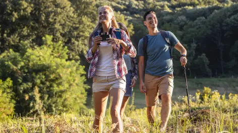 Ein Mann und eine Frau wandern auf einer Lichtung.