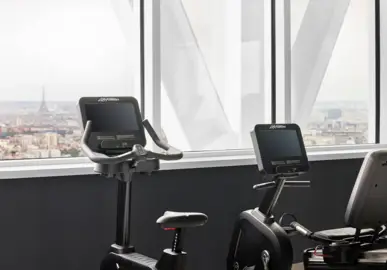 Fitness equipment in front of the Fesnter with a view of the Eiffel Tower.