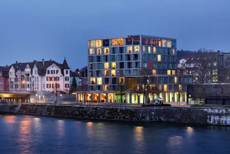 Blick auf das Hotel bei Nacht. Vereinzelt sind die Zimmer beleuchtet.