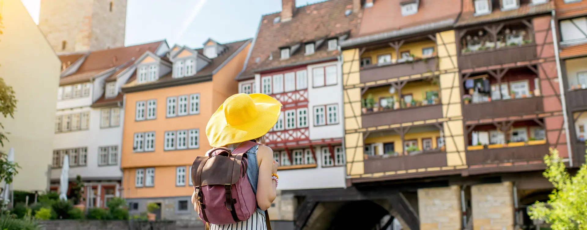 Frau mit gelben Sonnenhut schaut auf die Krämerbrücke.