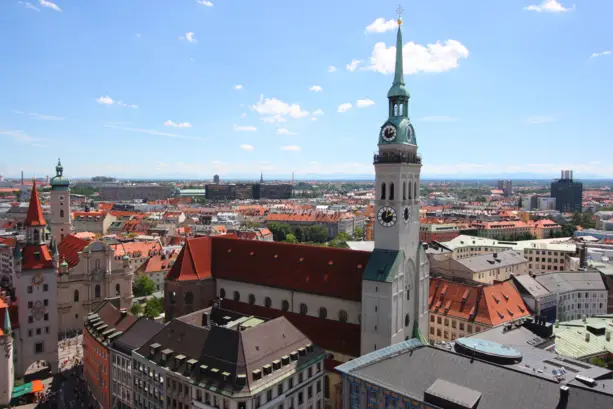 Blick auf die Peterskirche im Vordergrund und Münchener Häuser im Hintergrund.