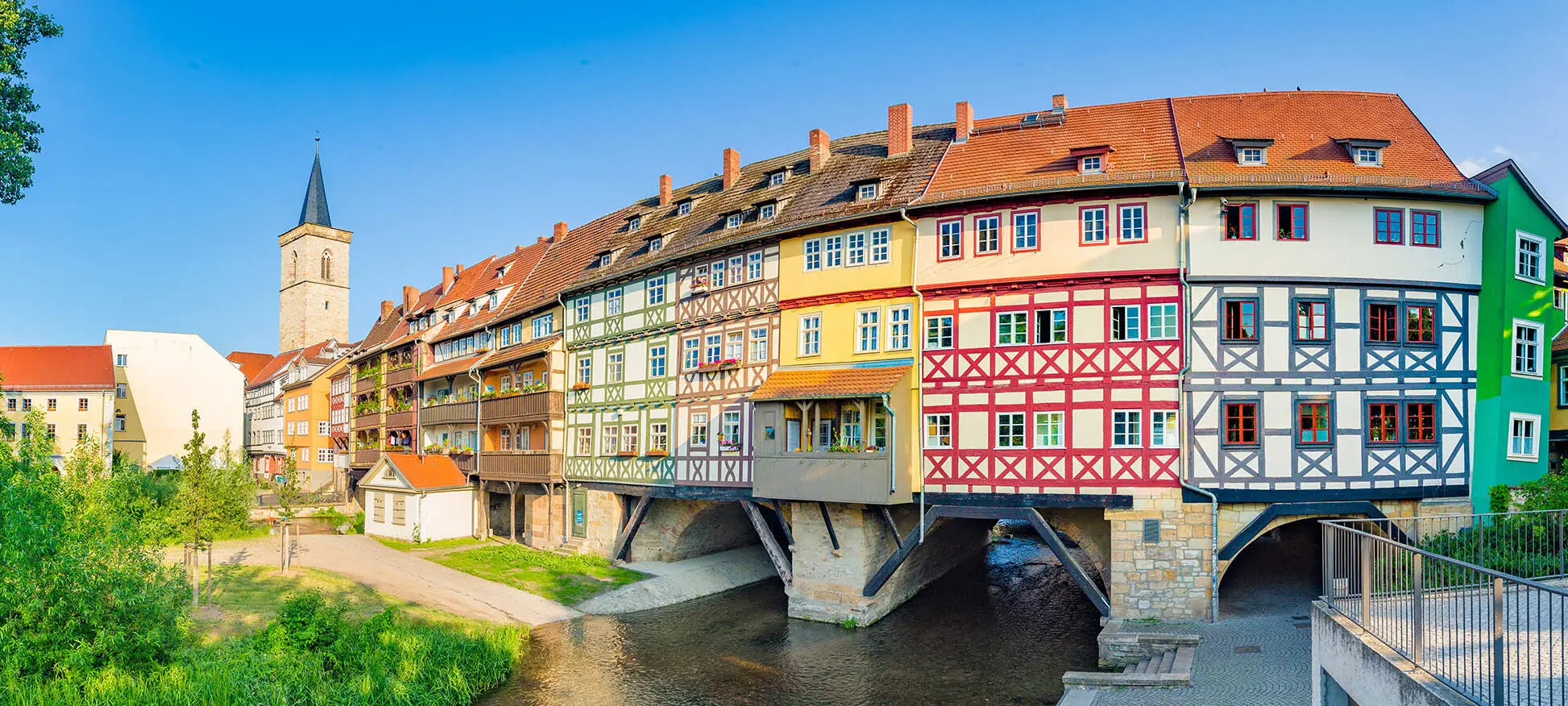 Blick auf die Krämerbrücke mit bunten Fachwerkhäusern. Links im Hintergrund die Ägidienkirche.