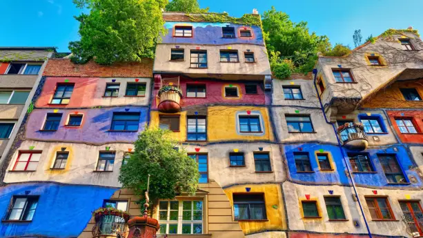 Buntes und bepflanztes Hundertwasserhaus von unten.