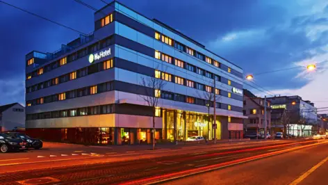 Außenansicht vom H+ Hotel Zürich bei Nacht.