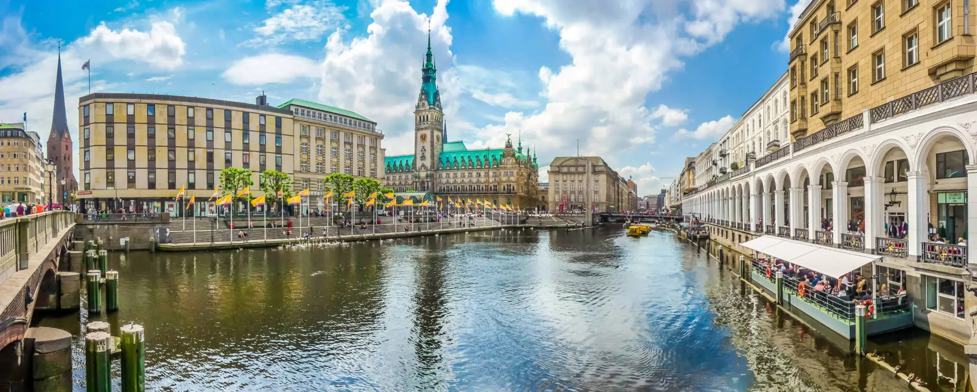 Binnenalster mit Rathaus und umgeben von vielen Geschäften.