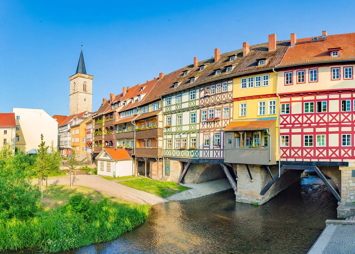 Blick auf die Krämerbrücke mit bunten Fachwerkhäusern. Links im Hintergrund die Ägidienkirche.