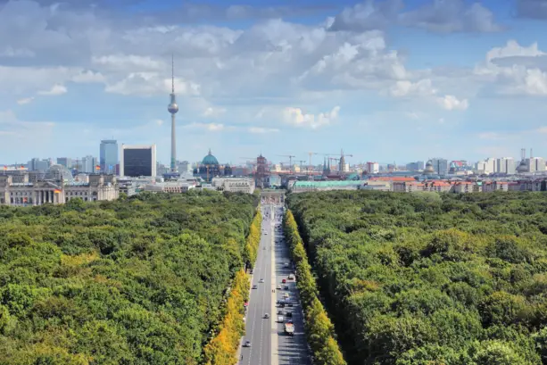 Überblick über den Tiergarten. Am Ende der Straße steht das Brandenburger Tor und der Fernsehturm im Hintergrund.