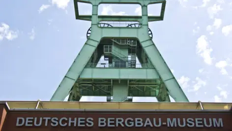 Blick von unten auf das Deutsche Bergbau-Museum mit dem Förderturm im Hintergrund.