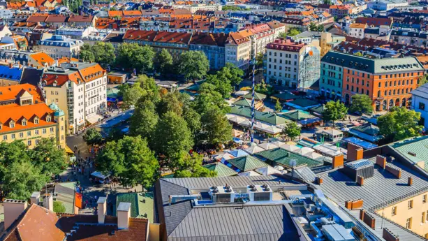 Verkaufsstände vom Viktualienmarkt von oben. Der Markt ist umgeben von Häusern.