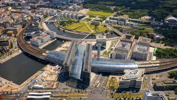 Berliner Hauptbahnhof von oben an der Spree. Im Hintergrund steht das Bundeskanzleramt.