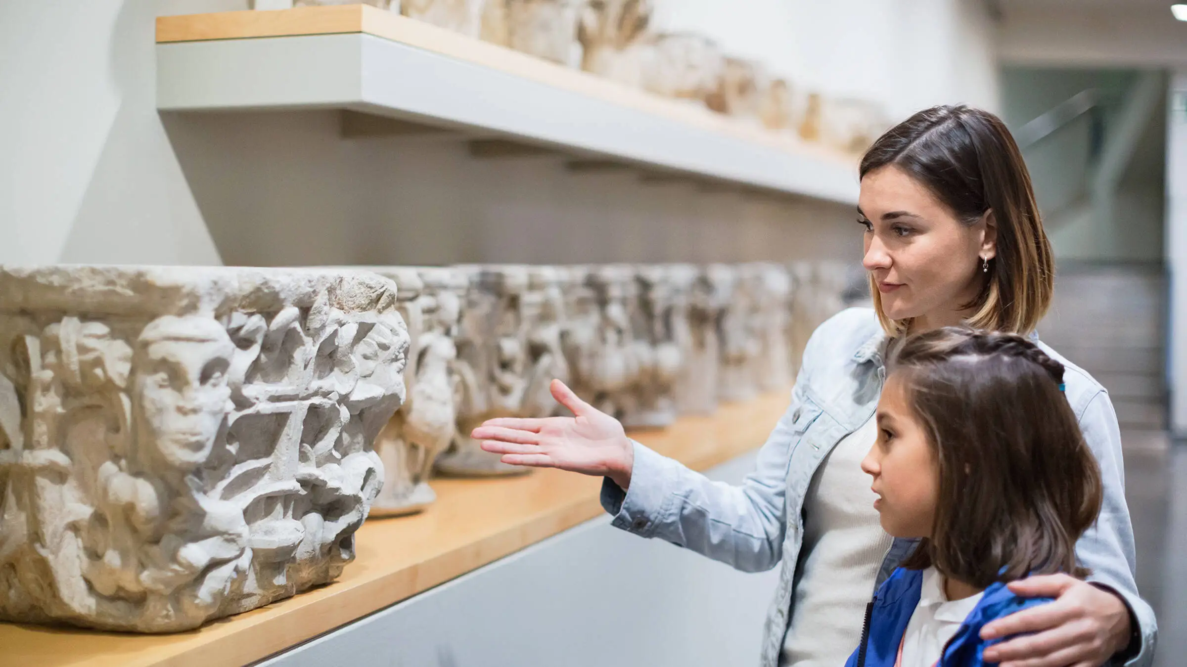 Madre e figlia guardano uno scaffale pieno di sculture