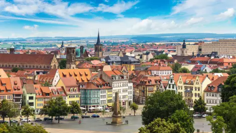 Vue d'ensemble d'Erfurt. Au premier plan, une grande place avec un monument.