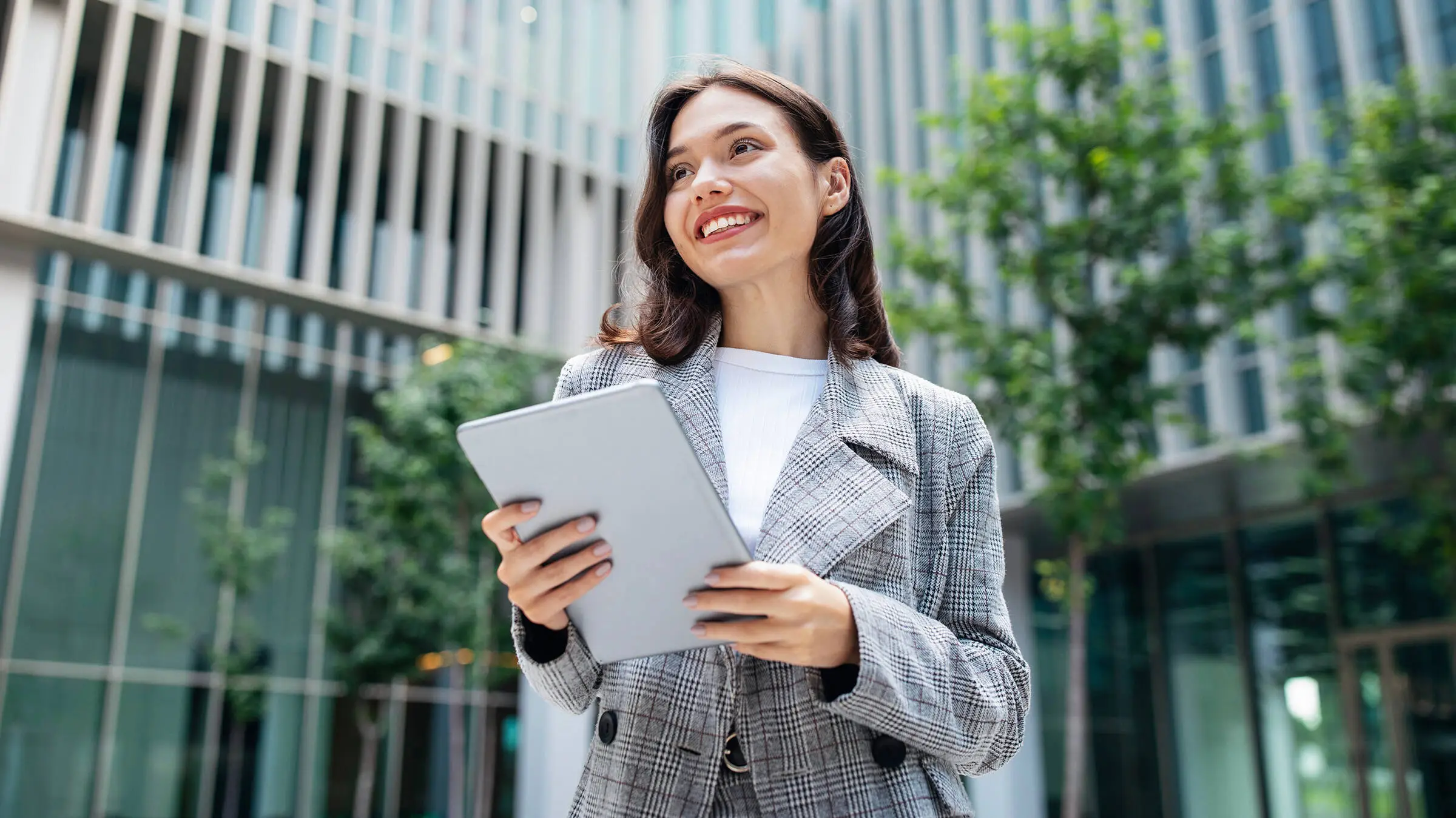 Man with a grey suit holding a tablet